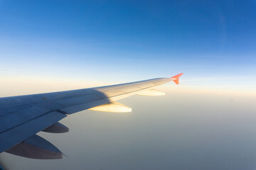 Fototapeta na wymiar Airplane wing on blue sky cloud window view travel background