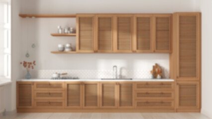 Blurred background, provencal wooden kitchen. Cabinets with shutters and rattan drawers, sink and gas hob, pottery and decors. Parquet, interior design, front view