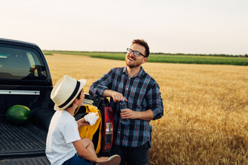 father and son together on wheat field. examine crop