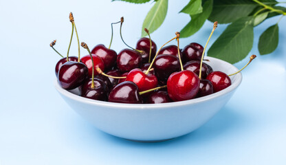 Juice and fresh cherry with leaf and water drops on blue background. Sweet red berry cherries. Summer fruit Background