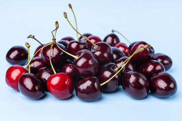 Juice and fresh cherry with leaf and water drops on blue background. Sweet red berry cherries....