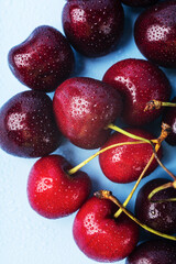 Juice and fresh cherry with leaf and water drops on blue background. Sweet red berry cherries. Summer fruit Background