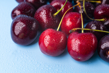 Juice and fresh cherry with leaf and water drops on blue background. Sweet red berry cherries. Summer fruit Background