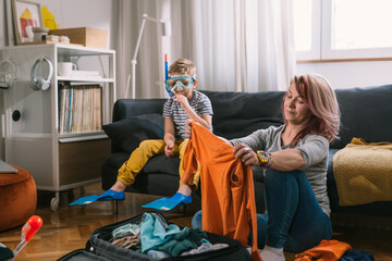 mother and son packing suitcases for summer vacation