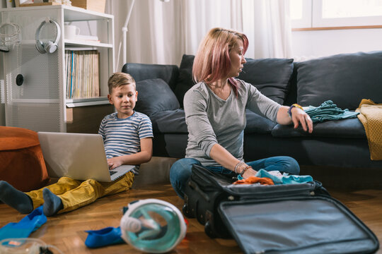 mother and son packing suitcases for summer vacation