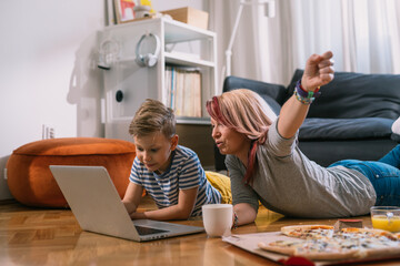mother and son watching movie on laptop at home