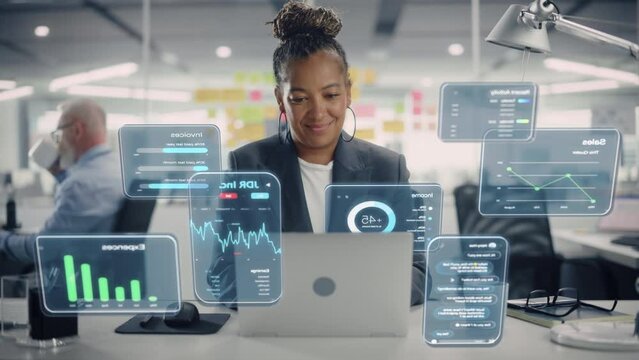 Female Project Manager Working on Computer in Office. Augmented Reality Corporate, Financial and Business App Icons Appear From Worker's Laptop. Productivity, Internet Connectivity and Online Concept.