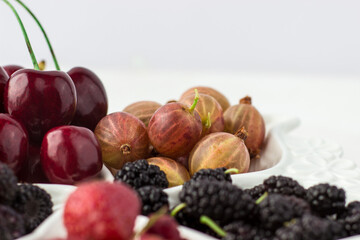 Close-up of gooseberries on a fruit plate on a white background. Ripe berries. Vitamins and a healthy lifestyle