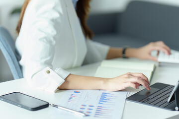 Asian businesswoman or business owner using Tablet computer and calculator