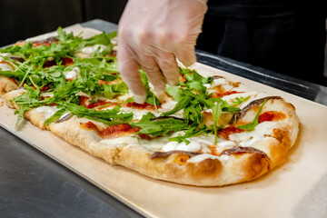 chef making pizza in cafe