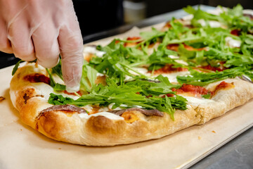 chef making pizza in cafe