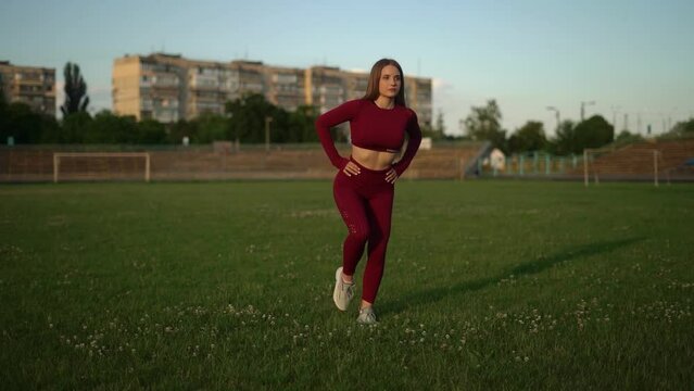 fitness girl goes in for sports at the stadium on green grass