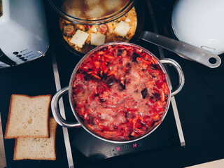 Hot traditional Russian Borsh soup made at home in a big cooking pot and omelette in the pan. Healthy vegetarian home cooking food. Vegan dinner.