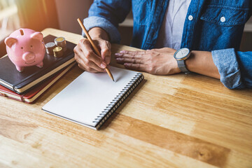 Business woman taking notes on income and expenses, saving for the future after retirement, saving ideas