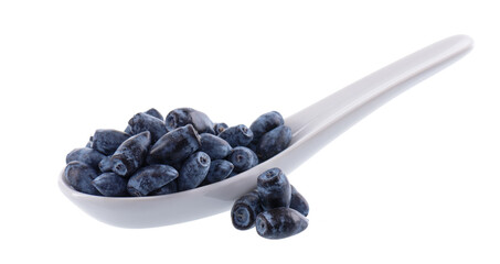 Honeysuckle berries white ceramic spoon, isolated on white background. Ripe berries of honeysuckle. Clipping path.