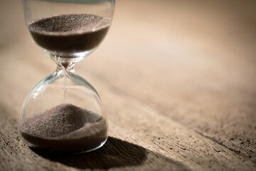 hourglass (sand clock) on an old wooden table, Hourglass as time passing concept for business...