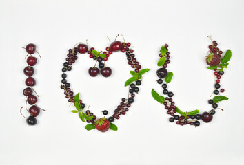 Declaration of love from fresh berries and green mint leaves on white background.  Words made of  fresh fruits and berries concept. Top view, flat lay, Free copy space