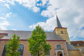 Fototapeta premium Tower of an ancient church in bright sunlight in a blue sky in springtime, Voeren, Limburg, Belgium, June, 2022