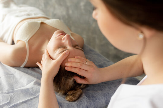 Cropped close up female osteopath fixing patient neck and head to cure spasm. Manual therapy center clinic. High angle