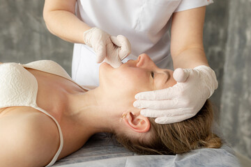 Female physiotherapist, chiropractor, osteopath doing anti wrinkle manual myofascial face massage...