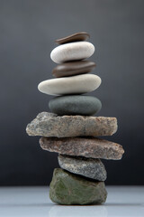 pyramid of stacked stones on a dark background. stabilization and balance in life