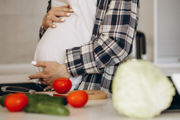 Pregnant woman at the kitchen preparing food