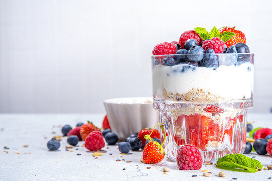 American independence holiday food, july 4 breakfast recipe idea. Summer diet healthy breakfast layered parfait dessert in a glass of yogurt, oatmeal, blueberries, strawberry berries