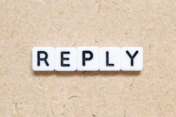 White tile alphabet letter with word reply on wood background