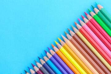 colored pencils with copy space on blue background educational concept