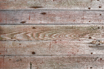 Closeup of weathered red boards arranged in a horizontal pattern
