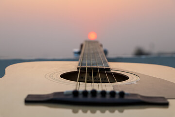 acoustic guitar on the beach at sunset