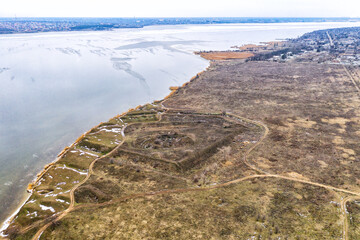 Fototapeta na wymiar Historical fortification in the field. The remains of the defense system of the city of Nikolaev. Flight over the winter river