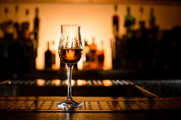 beautiful view on clear stemware of alcoholic drink on bar counter. - obrazy, fototapety, plakaty