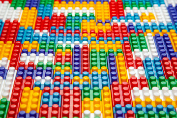 Abstract background texture of colored constructor blocks. Background of colorful plastic part of constructor. Pile of colored toy bricks.