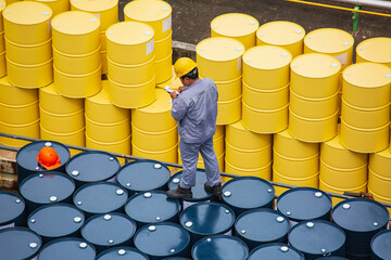 Male worker inspection record drum oil stock barrels yellow vertical or chemical for transportation...