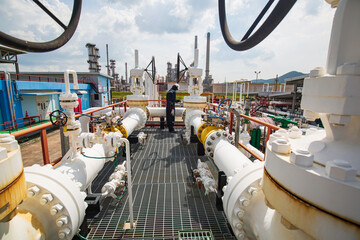 Male worker inspection at steel long pipes and pipe elbow in station oil factory during refinery...