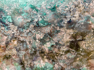 Spotted multi-colored background from decorative plaster with abstract spots. Unusual texture of this wall with beautiful patterns, creative surface background. Finishing coating for building cladding