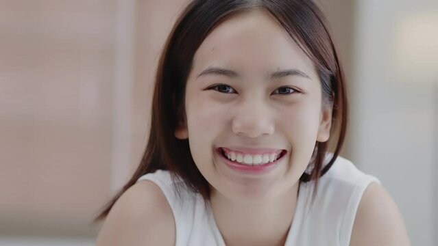 Beauty Face. Closeup headshot portrait of smiling Asian girl with natural makeup and healthy smooth skin. Beautiful girl with hydrated facial skin.
