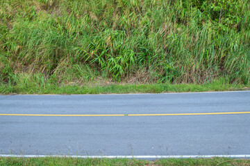 Obraz premium Side view of asphalt road with green grass.