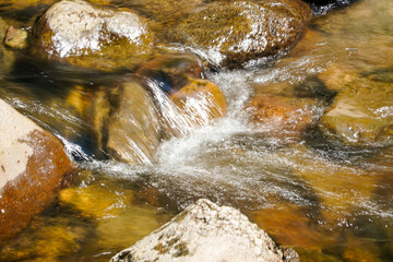 Closeup of Motion-Blurred Water Rapids Flowing over a Cobble Sto