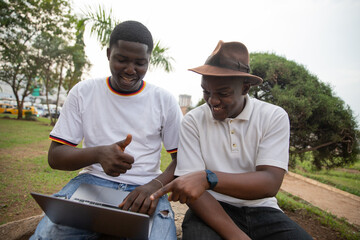 Two students study together using laptop in Africa at a public park