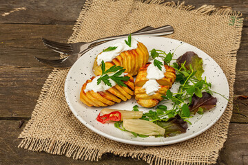 Baked accordion potatoes with fresh greens mix, fermented vegetables, and pea sprouts
