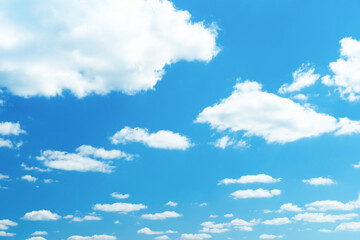 White clouds in the blue sky. Summer sky. Beautiful bright blue background. Curly clouds on a sunny day.
