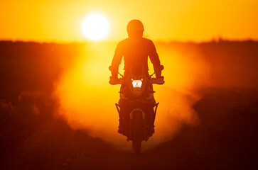 Riding an adventure motorbike on sunset