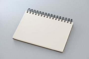 Spiral blank notebook on the gray background.