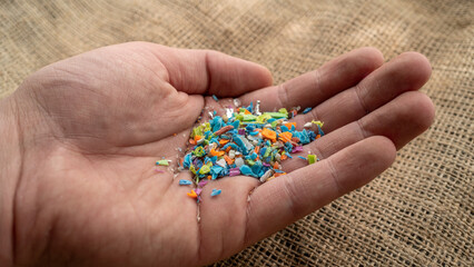 Close-up on micro plastic particles in a person hand. The concept for water pollution and global...