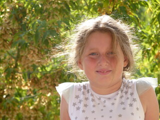 smiling, embarrassed looking beautiful young girl in the nature.