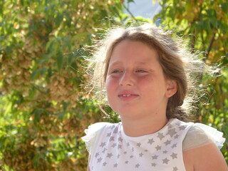 smiling, embarrassed looking beautiful young girl in the nature.