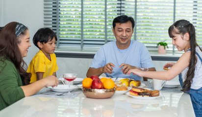 Family eating breakfast together, father  with mother and daughter sitting at the dining table, having breakfast in the dining room.Family and Relationship Concepts