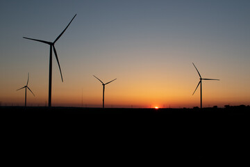 wind turbines producing wind power at sunset